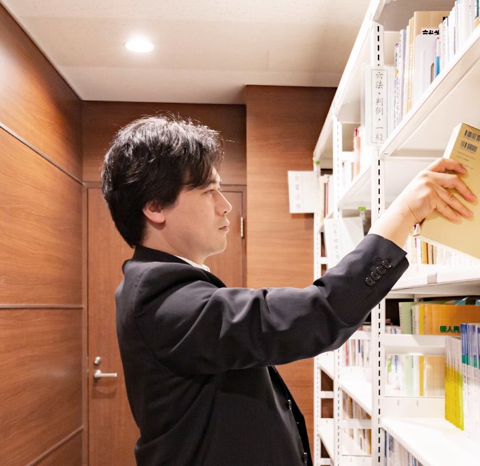 本を取る大張弁護士の写真